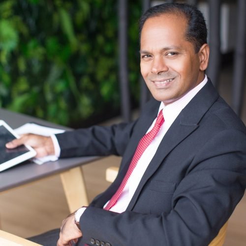 happy-indian-business-man-using-tablet-cafe-e1734021241975.jpg